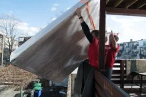 Labor Only Movers without a truck hoisting a box spring that couldn't fit up the stairs